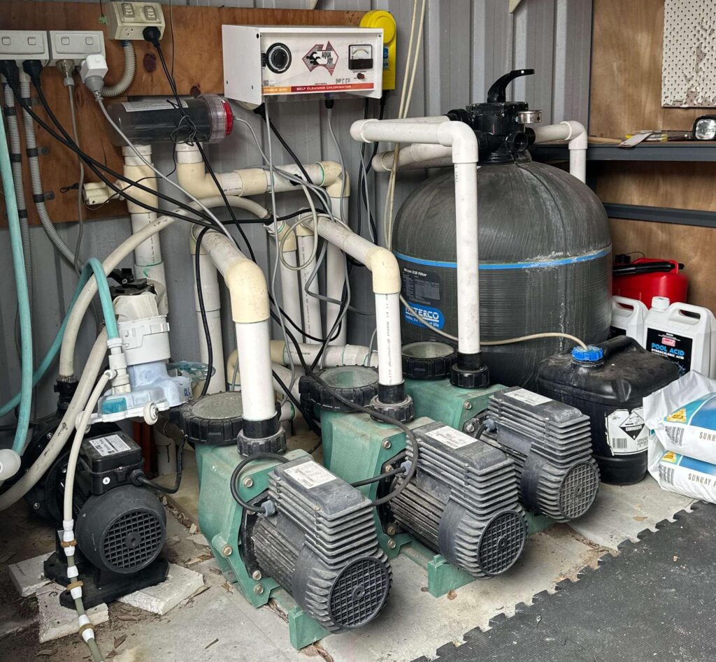 Pool equipment shed with pool pumps, a filter, a salt chlorinator and pool chemicals